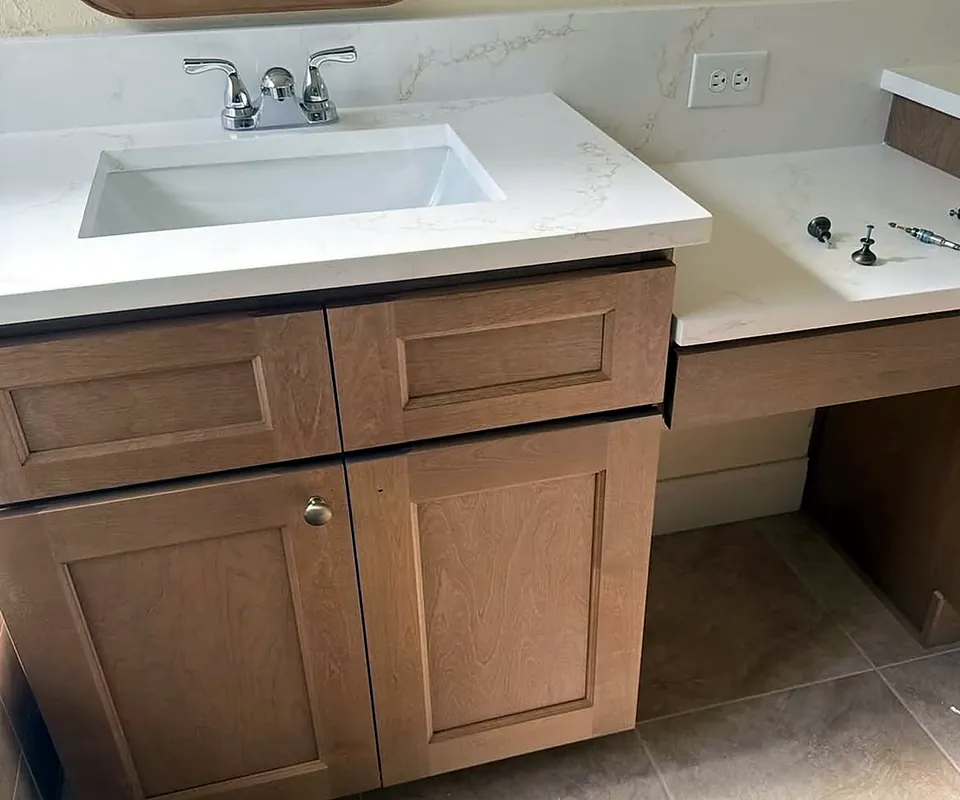 Mueble de baño de madera con encimera blanca de cuarzo y lavabo instalado